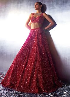 Make a bold statement in the exquisite Red Sequins Embroidered Bridal Lehenga with Veil, crafted from luxurious soft net fabric. The flowing red lehenga is intricately embroidered with tonal sequins, crystals, glass beads, and hand-dyed pearls, creating a design that shimmers with opulence. Paired with an intricately embroidered blouse, perfectly complementing the lehenga’s lavish details. The look is completed with a matching dupatta and a long veil, both bordered and embellished to perfection. This ensemble masterfully blends tradition with contemporary style, ensuring that the bride or bride-to-be stands out with elegance and grace on her special day. Composition : Lehenga, Blouse, Veil and Dupatta - Net Care: Dry Clean Only and Vacuum Storage This product can be customized for sleeves, Red Sequined Sets For Navratri, Designer Red Sequined Sets, Red Sequined Dress For Navratri, Elegant Red Lehenga With Sequins, Red Floor-length Choli With Sequins, Red Sequined Floor-length Choli, Red Sequined Choli For Navratri, Red Sequined Sharara With Traditional Drape, Red Anarkali Choli For Party