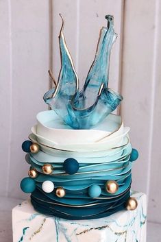 a multi layer cake with blue frosting and gold decorations on it's sides