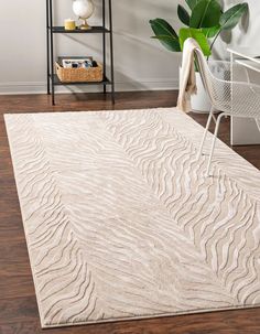 a white rug with wavy lines on it in a living room next to a chair and potted plant