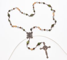 a rosary with a crucifix on it is laying on a white surface