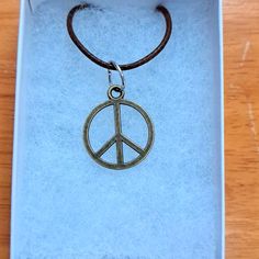 Handmade Peace Sign Necklace Made With Bronze Peace Sign On Brown Cord Chain. Pendant Peace Sign Measures 18mm In Antique Bronze. The Peace Sign Is A Symbol Of Peace And Hope. Chain Is Adjustable With Claw Clasp Closure. Box Display Only. Pouch Included Free. New And Unused Item. Contact Me With Any Offers. Casual Round Pendant Jewelry Gift, Casual Round Pendant Jewelry As A Gift, Nickel Free Casual Jewelry, Casual Nickel Free Round Jewelry, Casual Nickel Free Jewelry, Nickel-free Casual Round Jewelry, Nickel-free Round Casual Jewelry, Adjustable Round Charm Necklace Nickel Free, Adjustable Symbolic Round Charm Necklaces