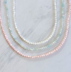 Sparkling round gemstone beaded necklace featuring semi-precious stones of turquoise amazonite, white mother of pearl, or pink mother of pearl. Amazonite Round Beads Necklace For Gift, Amazonite Gemstone Beaded Necklace With Round Beads, Elegant Amazonite Necklace With Faceted Beads, Amazonite Gemstone Beaded Necklaces With Round Beads, Amazonite Gemstone Beaded Necklace, Single Strand Amazonite Beaded Necklaces As Gift, Amazonite Necklace With Natural Stones, Handmade Amazonite Round Beads Necklaces, Gift Amazonite Single Strand Beaded Necklace