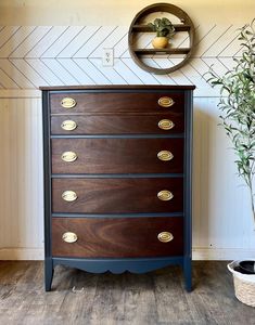 a wooden dresser sitting next to a potted plant on top of a hard wood floor