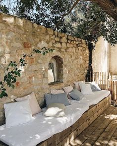 an outdoor seating area with pillows on it