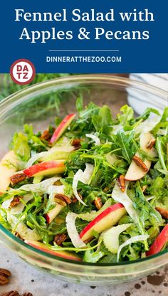 a salad with apples and pecans in a glass bowl on top of a table