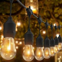 a bunch of light bulbs hanging from a wire with lights on them in the background