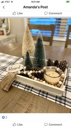 a wooden tray filled with pine cones and other decorations on top of a dining room table