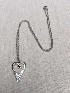 "This is such a unique and whimsical heart pendant necklace. It has incredible detail and another little heart showcased inside the main heart. This would make a very sweet and meaningful gifts for a loved one on any occasion. The heart measures 1\" long by 5/8\" wide and is made from allergy free plated silver. It hangs from a simple 18\" stainless steel necklace chain. I have matching earrings in my shop, if you would like the whole set. Here is the link https://etsy.me/30EwF2x Thanks for stop Bohemian Heart Pendant Charm Necklace Gift, Heart Charm Necklace With Round Pendant, Metal Heart Necklace With Open Heart Charm, Heart Charm Metal Necklace, Bohemian Silver Heart Charm Necklaces, Metal Heart Pendant Necklace, Bohemian Silver Heart Charm Necklace, Metal Heart Pendant Necklace For Valentine's Day, Metal Heart Necklace With Heart Beads