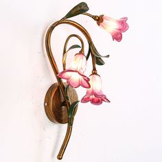 a wall light with pink flowers on it's arm and two lights attached to the side