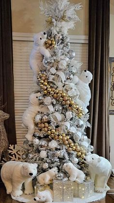 a white christmas tree decorated with gold and silver ornaments, polar bears and snowflakes