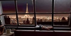 a window with a view of the eiffel tower at night from it's windowsill