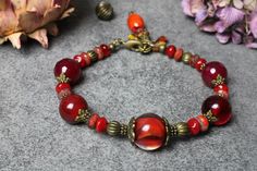 Beautiful bracelet made of wrapped handmade and Bohemian glass beads and gemstones such as agate. In shades from red to pink to dark red. With bronze-colored Intermediate parts and close with a carabiner. Pearl size: from 6 mm to 10 mm Total length with clasp: 21.5 cm Wrist circumference: 18.5 cm Width: 1cm Red Carnelian Bohemian Bracelets, Handmade Red Czech Glass Beaded Bracelets, Bohemian Red Carnelian Bracelets, Red Czech Glass Bracelet With Round Beads, Bohemian Red Beaded Bracelets With Spacer Beads, Bohemian Red Beaded Bracelet With Spacer Beads, Red Czech Glass Bracelets With Colorful Beads, Handmade Red Agate Bracelets, Unique Red Bracelets With Natural Stones