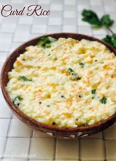 a bowl filled with food sitting on top of a white tile floor next to green leaves