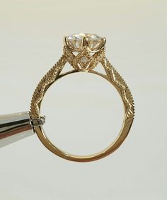 a close up of a ring with a diamond on it's center stone and an arrow in the middle