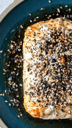 a piece of bread with sesame seeds on it sitting in a frying pan filled with oil and sprinkles