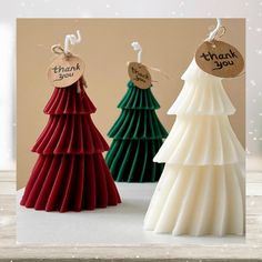 three small christmas trees with thank you tags on them