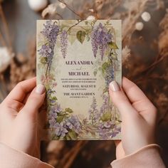 a person holding up a wedding card with flowers on it