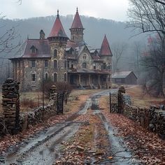 an old stone house in the middle of a field with trees and leaves on the ground