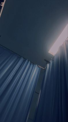 the light shines brightly through the blue curtained room's window sill