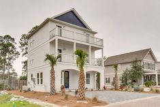 a white house with palm trees in front of it