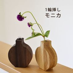 two wooden vases with flowers in them on a table