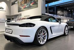 a white sports car parked in a showroom