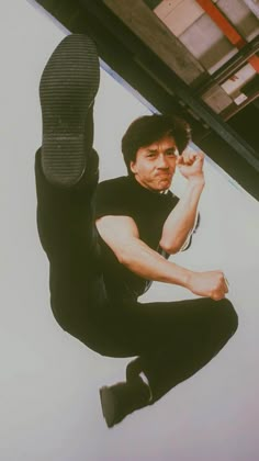 a man sitting on the ground with his legs crossed and one foot in the air