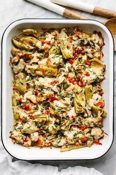 a casserole dish filled with artichokes and chicken