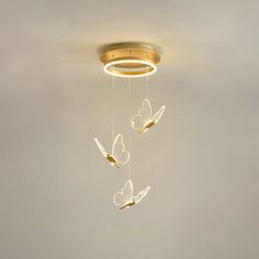 three butterflies suspended from a ceiling light