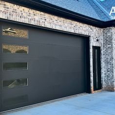 a black garage door in front of a brick building