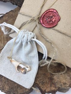 a small bag with a wax stamp on it sitting next to a piece of wood