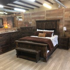 a large bed sitting inside of a bedroom on top of a hard wood flooring