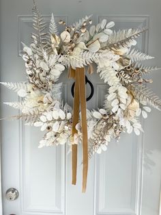 a white wreath hanging on the front door