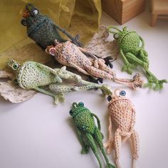 five crocheted frog figurines sitting next to each other