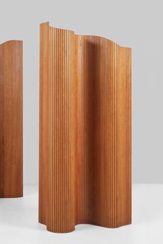 three tall wooden panels with vertical slats on the top and bottom, in different sizes