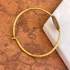 24KT yellow gold-plated + sterling silver replica Roman coin bangle with diamond. Double-sided silver coin set with textured, matte finish to the gold bangle! Length: 7" approx. Diameter: 60mm Band width: 2mm Weight: 11.80 grams (1) .01 CT natural, round diamond 21mm round replica coin Hook style clasp 925 sterling silver purity with 24KT gold plating Adjustable Engraved Gold Bracelet, Engraved Adjustable Gold Bracelet, Gold Tarnish-resistant Round Bangle, Hammered Yellow Gold Coin Jewelry, Yellow Gold Etched Bracelets, Yellow Gold Brass Bracelet, Byzantine Style Gold-plated Round Jewelry, Adjustable Yellow Gold Round Disc Jewelry, Yellow Gold Round Brass Bracelets