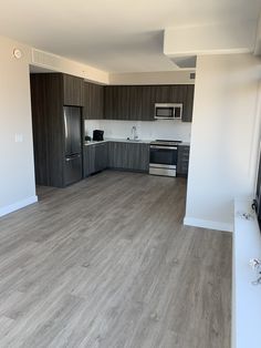 an empty kitchen and living room with wood flooring