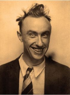 an old black and white photo of a smiling man