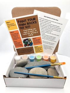 an open box filled with rocks and paints