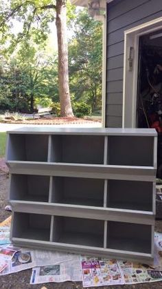 an open garage door with several shelves on the ground