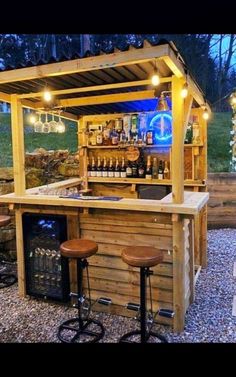 an outdoor bar with stools and lights