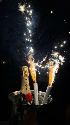 two champagne bottles in a bucket with sparklers