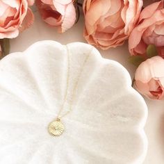 DESCRIPTION: The Sunshine Necklace - Gold sunburst coin pendant on a dainty gold filled chain. We love this celestial + minimalist look!MATERIALS:Chain, Clasp, Jump Rings - Gold Filled Sun Coin Pendant - Gold plated, CZ stoneSIZE:Approximately 6/8” wide MATCHING EARRINGS:https://etsy.me/3dQCaS1PACKAGING:Your necklace will arrive on a Dainty Doe signature jewelry card placed in a white jewelry box, with a bow and tag, perfect for gift giving!GIVING A GIFT:We would love to include a hand written n Gold Sun Design Round Pendant Necklace, Gold Necklace With Sun Design Round Pendant, Gold Medallion Necklace With Sun Design, Gold Dainty Sun Design Charm Necklace, Dainty Gold Charm Necklace With Sun Design, Gold Plated Sun Design Necklace Gift, Gold Plated Sun Design Necklace As Gift, Gold Sun-shaped Jewelry For Everyday, Dainty Brass Coin Necklace For Gift