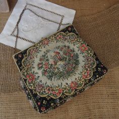 "Vintage Black Tapestry Purse / Black Handbag 1940's / Floral And Brass Clasp Evening Bag Beautiful black clutch with a floral garden design tapestry purse. The clasps is ornate gold metal with 2 black stones. Cream satin interior is in good condition with one pocket. In good vintage condition.   Measures approx:  6 1/4\" x 5 1/2\" This is a vintage item , sold as is with its original charm and patina." Vintage Tapestry Bag For Evening, Vintage Evening Bag In Tapestry Material, Formal Vintage Tapestry Bag, Vintage Formal Tapestry Bag, Rectangular Embroidered Bags For Vintage Events, Vintage Tapestry Pouch Bag, Embroidered Rectangular Bag For Vintage Events, Embroidered Rectangular Bags For Vintage Events, Vintage Tapestry Bag For Formal Occasions