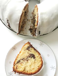 a slice of cake on a plate next to a bundt cake with white frosting