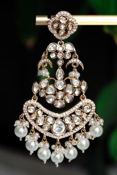 Embrace timeless elegance with our Chashni Chandbali kundan earrings: a masterpiece of traditional craftsmanship and contemporary allure. A stunning piece of unique South Asian jewelry, Chashni is an elegant 21K gold plated chandelier earring adorned with a shimmering Alhambra motif, dangling mini crescents, and lustrous pearls. Chashni's kundan stones are meticulously hand-set by master artisans to create an ethereal array of light that dazzles in every environment. Enhance even your most elega Luxury Temple Jewelry Chandbali Bridal Sets, Luxury Chandbalis With Intricate Design For Diwali, Luxury Fusion Style Chandbalis For Wedding, Luxury Chandbalis With Intricate Design For Reception, Luxury White Chandbali Pearl Necklace, Luxury Hand Set Chandbali Chandelier Earrings, Luxury Traditional Chandbali Pearl Earrings, Cheap Traditional Chandbali Jewelry, Luxury Chandbali Bridal Earrings