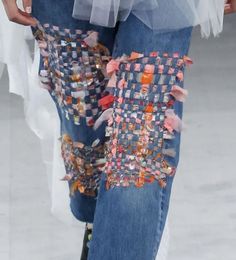 a woman's jeans with buttons and tulle on the bottom are shown in close up