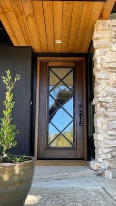 a large potted plant sitting in front of a door on a stone house porch