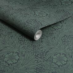 a green wallpaper with an intricate design on it's back side and silver foiled edge