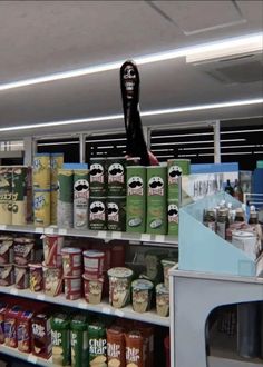 an assortment of food items on display in a grocery store with a fake human head sticking out of the top shelf